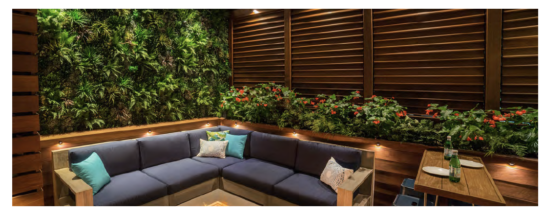 Outdoor terrace with lush green walls and modern seating