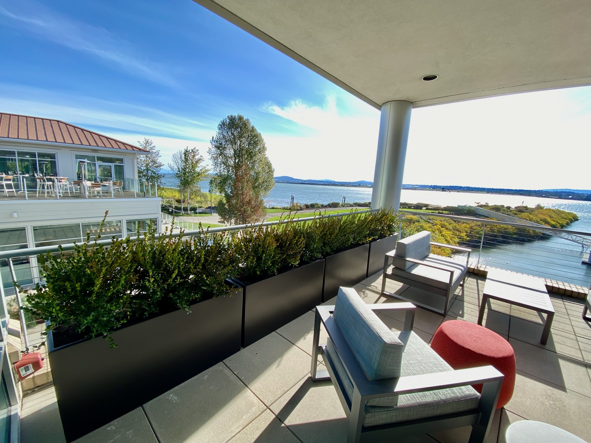 Luxury waterfront terrace with hedge planters