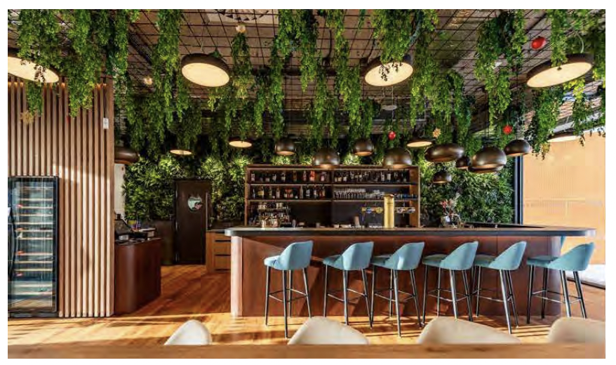 Modern restaurant interior with extensive green wall ceiling and bar area